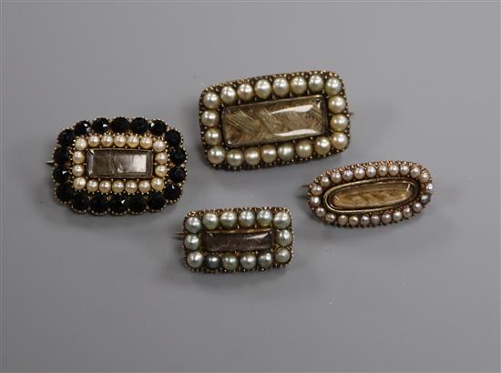 Four assorted Victorian yellow metal and split pearl or jet set mourning brooches, largest 22mm.